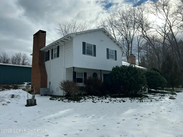 a front view of a house with a yard and potted plants