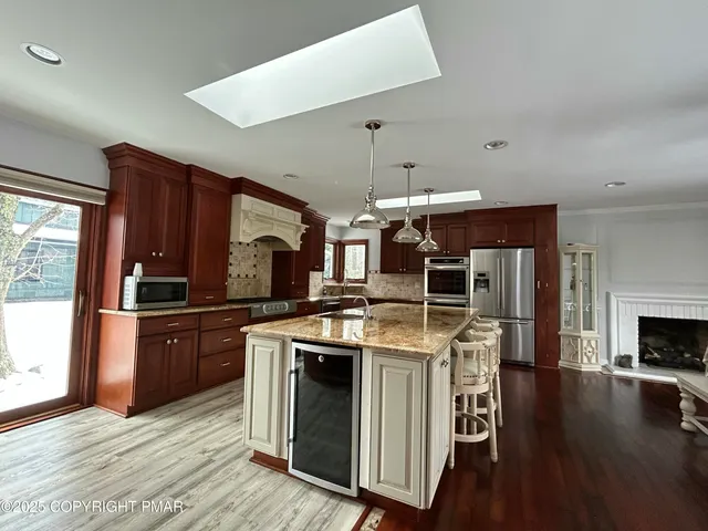 a kitchen with wooden floors and stainless steel appliances