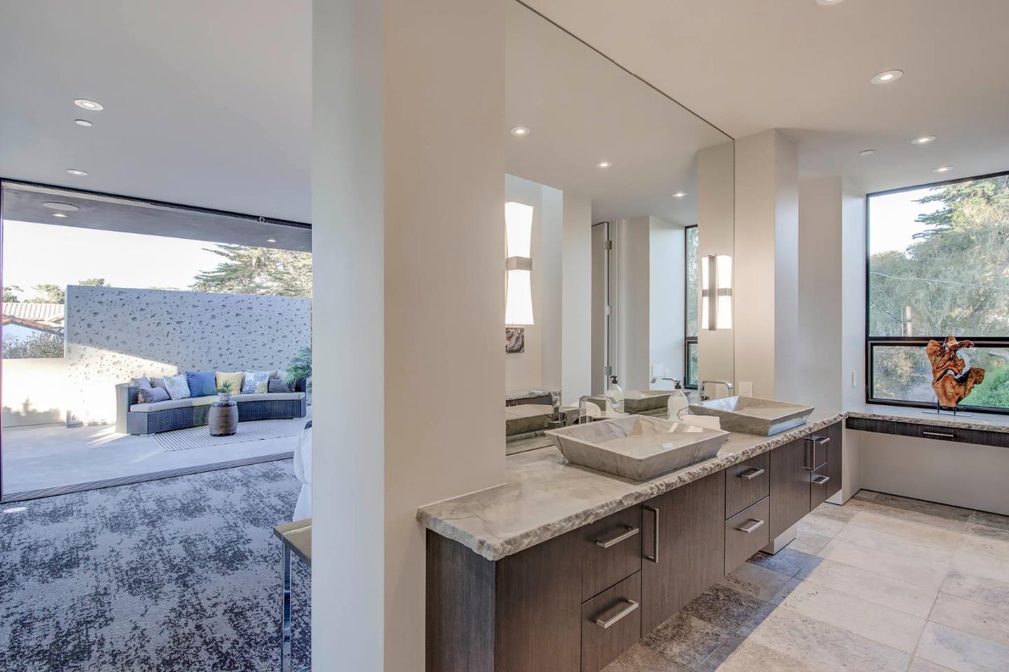 2889 17 Mile Drive Pebble Beach, CA 93953 - Photo 12 of 17 a bathroom with a granite countertop sink and a mirror