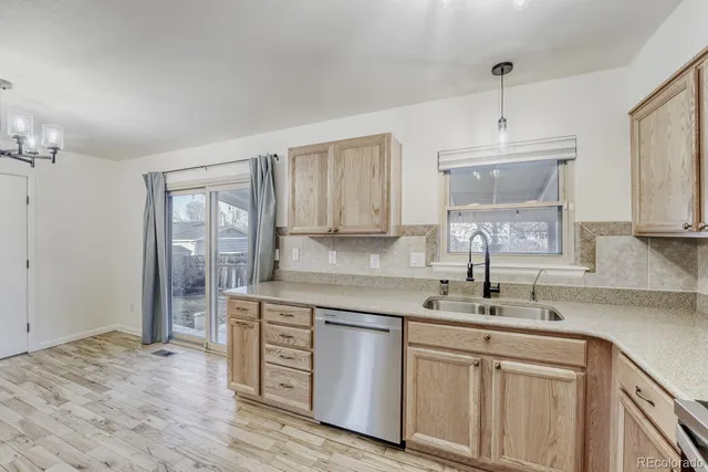 a kitchen with stainless steel appliances granite countertop a sink a stove and cabinets