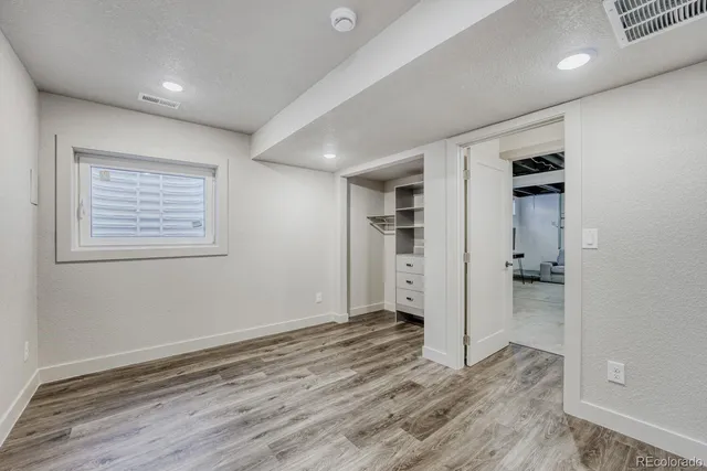 a view of empty room with wooden floor