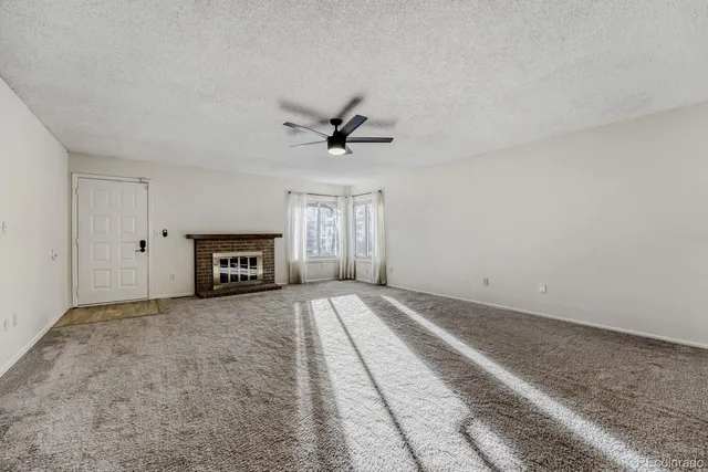 an empty room with fireplace and windows