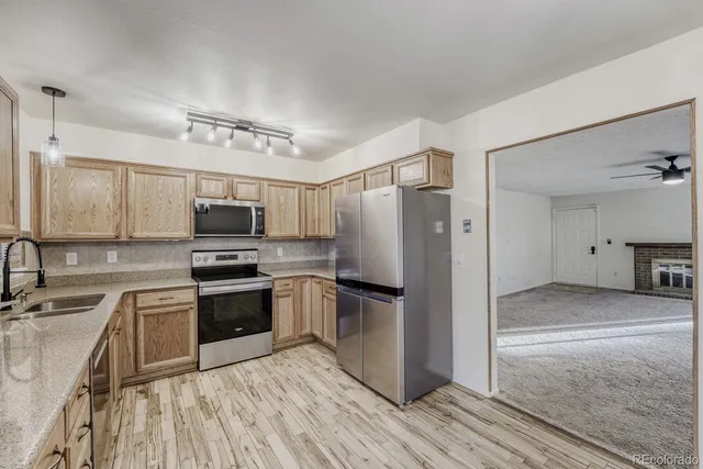 a kitchen with stainless steel appliances a refrigerator sink and microwave