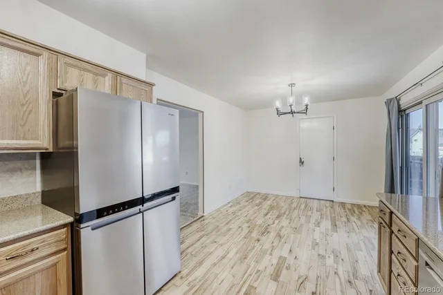a view of a refrigerator in kitchen and wooden floor