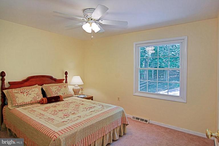 11412 Running Cedar Road Reston, VA 20191 - Photo 11 of 18 a bedroom with a bed and a chandelier