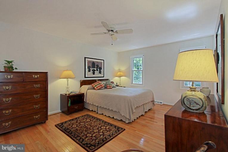 11412 Running Cedar Road Reston, VA 20191 - Photo 8 of 18 a bedroom with a bed and a lamp on dresser