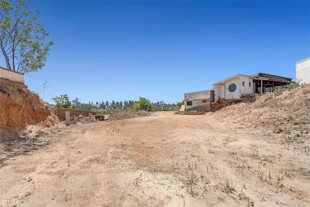 a view of a dry yard with a snow in the background