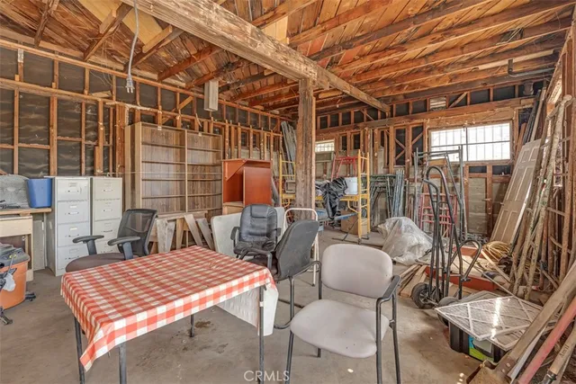a view of a patio with a table and chairs under an umbrella next to a road
