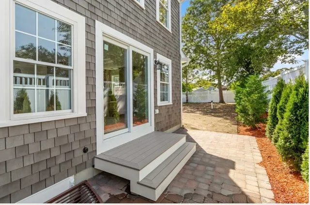 a view of house with backyard and glass windows