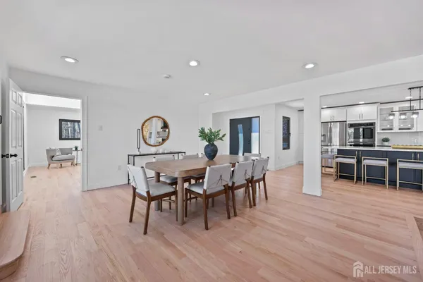 an empty room with wooden floor ceiling fan and windows