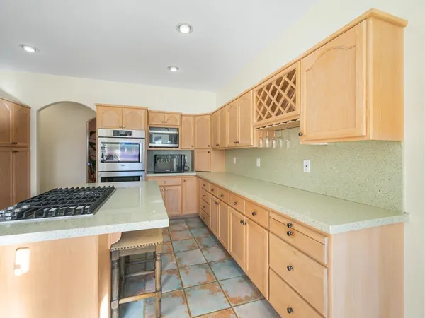a kitchen with stainless steel appliances granite countertop a sink and a refrigerator