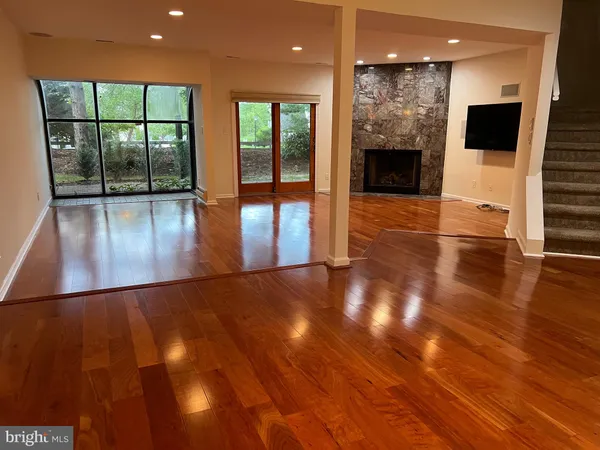 a view of a living room with hardwood floor and a large window