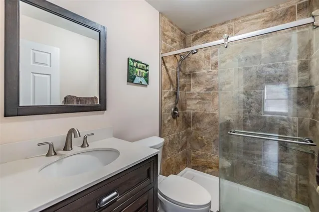 a bathroom with a sink a toilet and shower