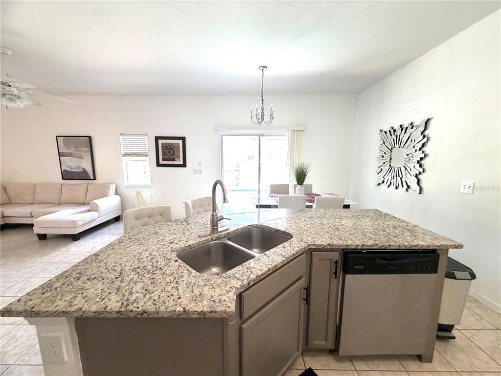 4573 Ada Lane Kissimmee, FL 34746 - Photo 8 of 37 a kitchen with a granite countertop sink and white cabinets