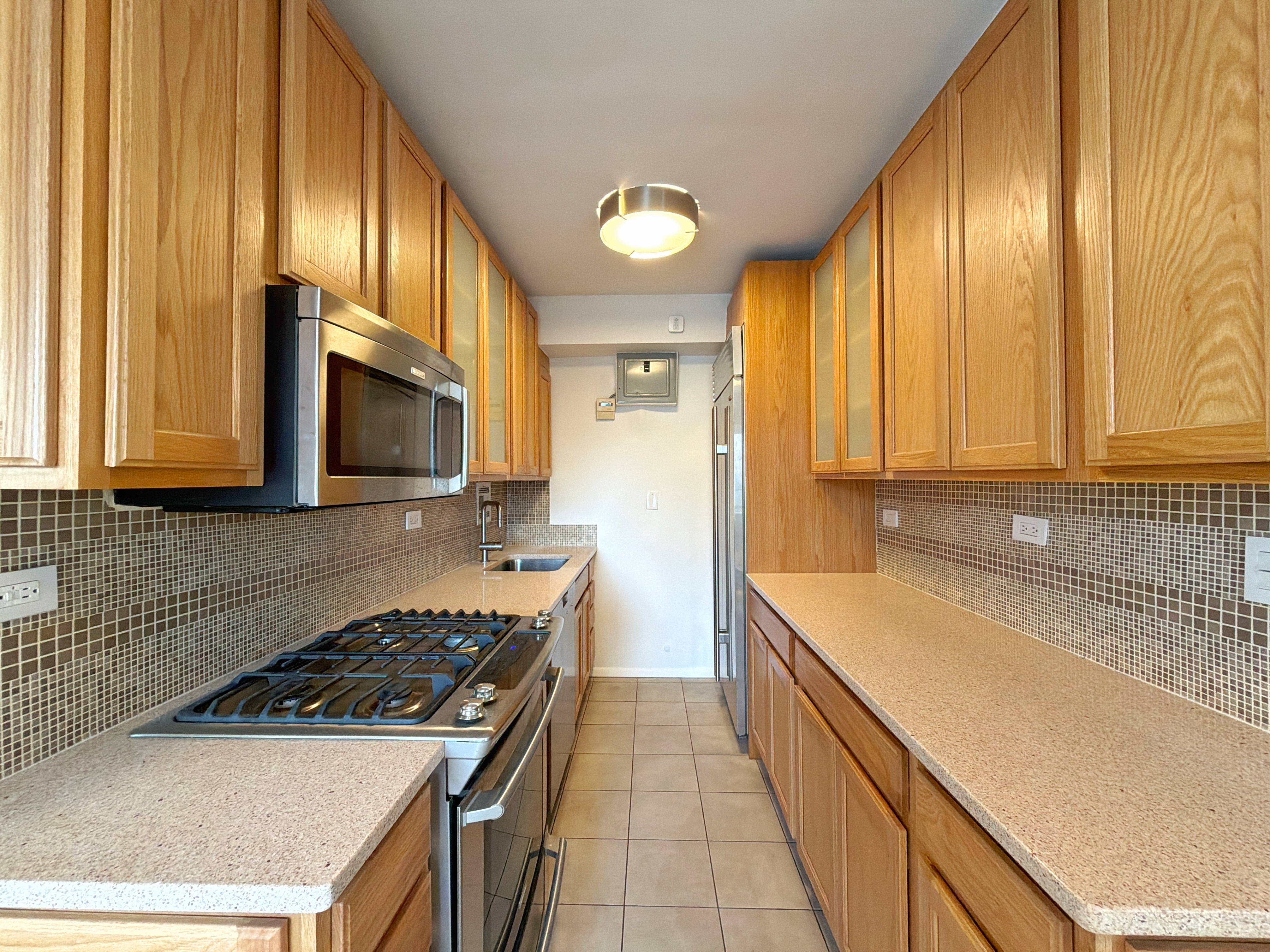 175 Adams Street, Unit 9DE Brooklyn, NY 11201 - Photo 10 of 18 a kitchen with a sink a stove and cabinets