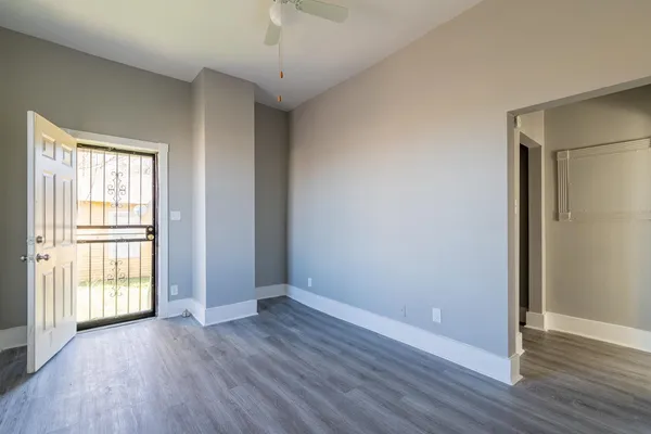 an empty room with wooden floor and windows