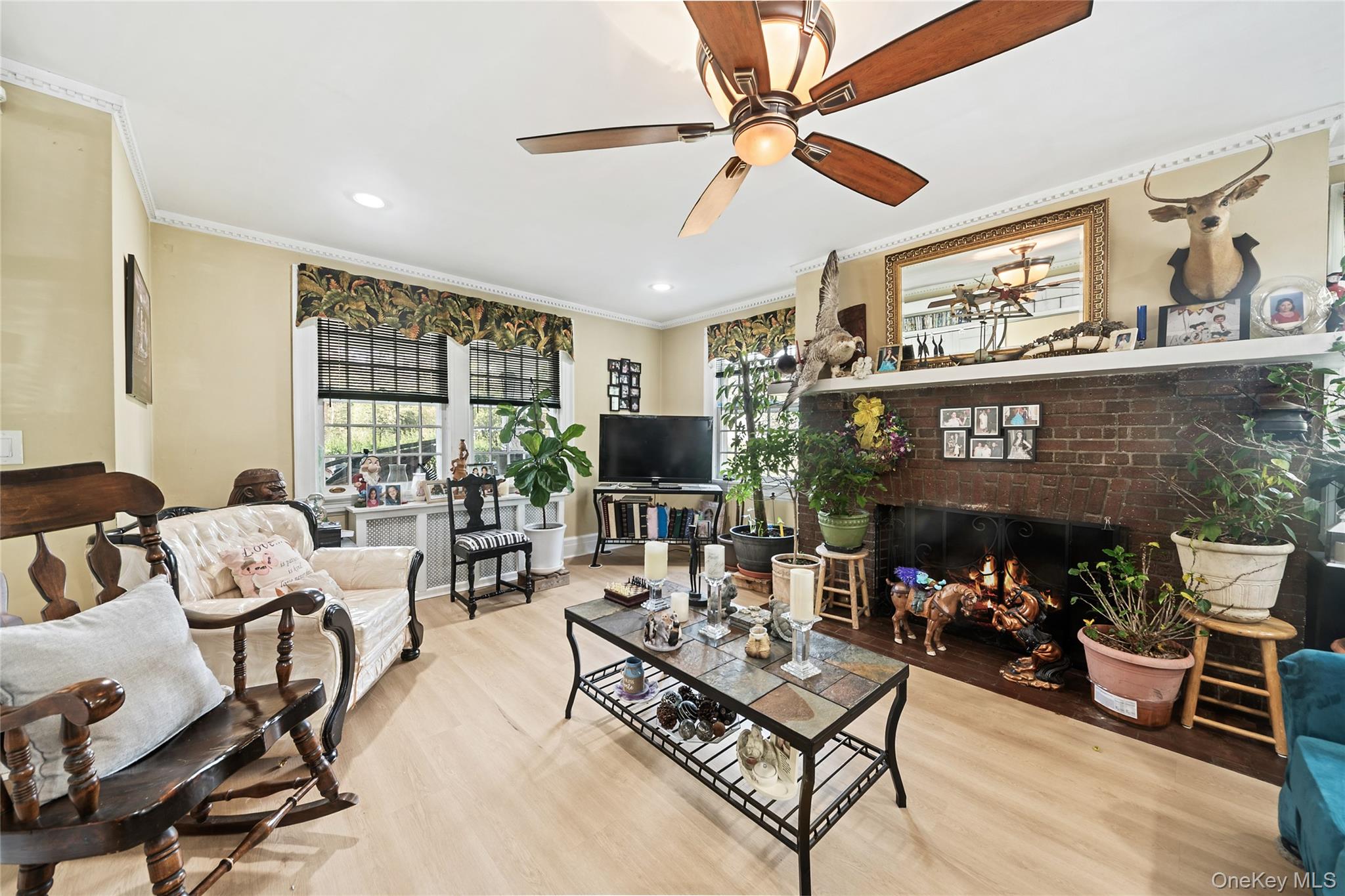 75 Chappaqua Road Briarcliff Manor, NY 10510 - Photo 11 of 50 Spacious living area featuring light wood-finish flooring, a ceiling fan with integrated lighting, and crown molding