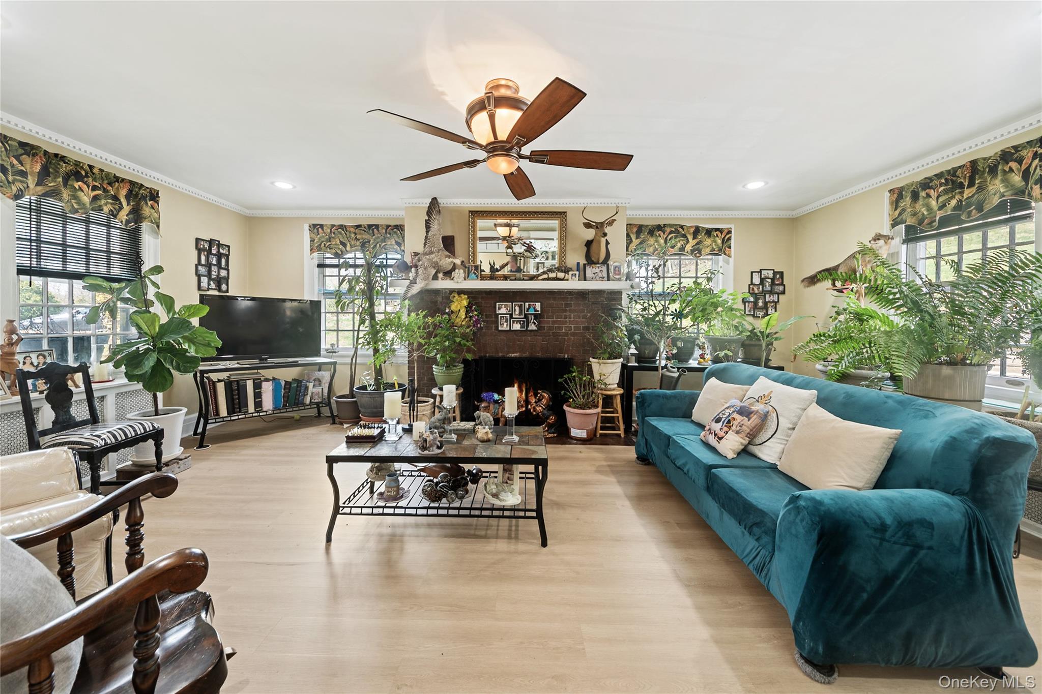 75 Chappaqua Road Briarcliff Manor, NY 10510 - Photo 12 of 50 Spacious living area featuring a brick fireplace, light wood-finish flooring, crown molding, a ceiling fan, and recessed lighting
