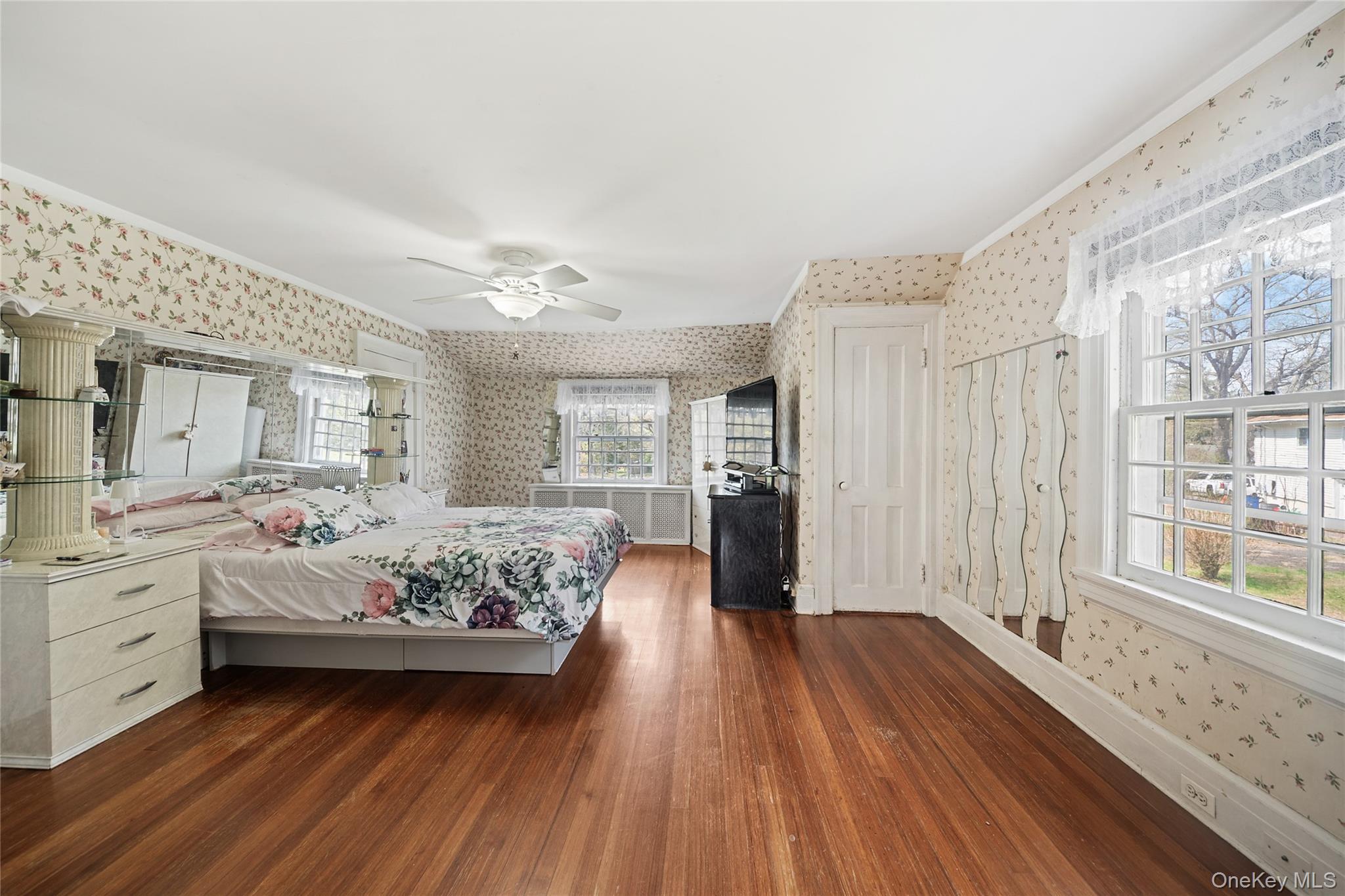 75 Chappaqua Road Briarcliff Manor, NY 10510 - Photo 19 of 50 Hardwood flooring in a bright room featuring multiple windows, a ceiling fan, and a white paneled door