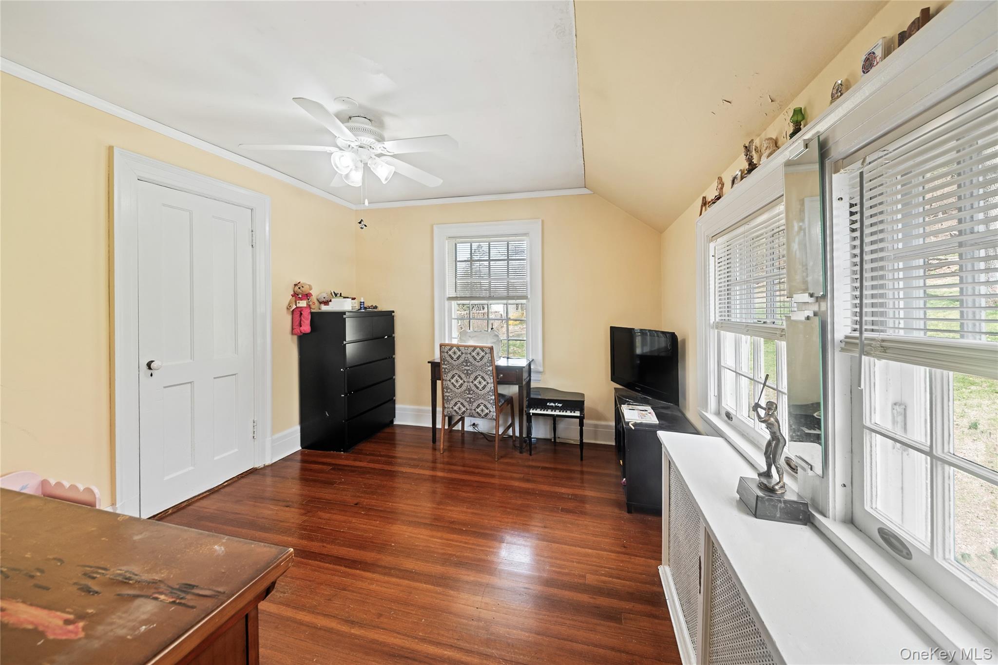 75 Chappaqua Road Briarcliff Manor, NY 10510 - Photo 22 of 50 Hardwood flooring throughout featuring a ceiling fan, two windows with white blinds, a two-panel interior door, and a built-in window ledge