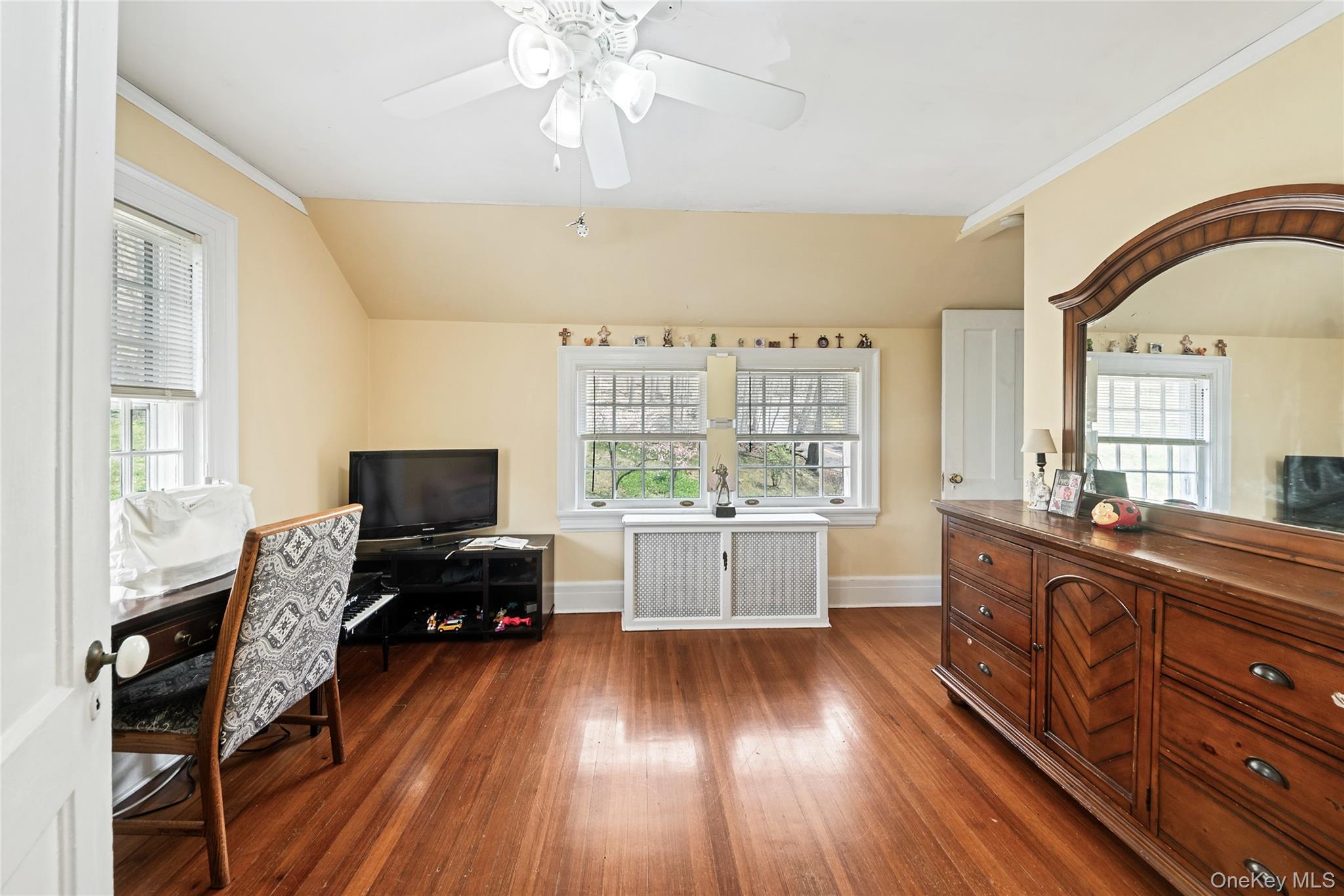75 Chappaqua Road Briarcliff Manor, NY 10510 - Photo 23 of 50 Hardwood flooring throughout this room featuring a ceiling fan, two double-hung windows, and a white paneled door