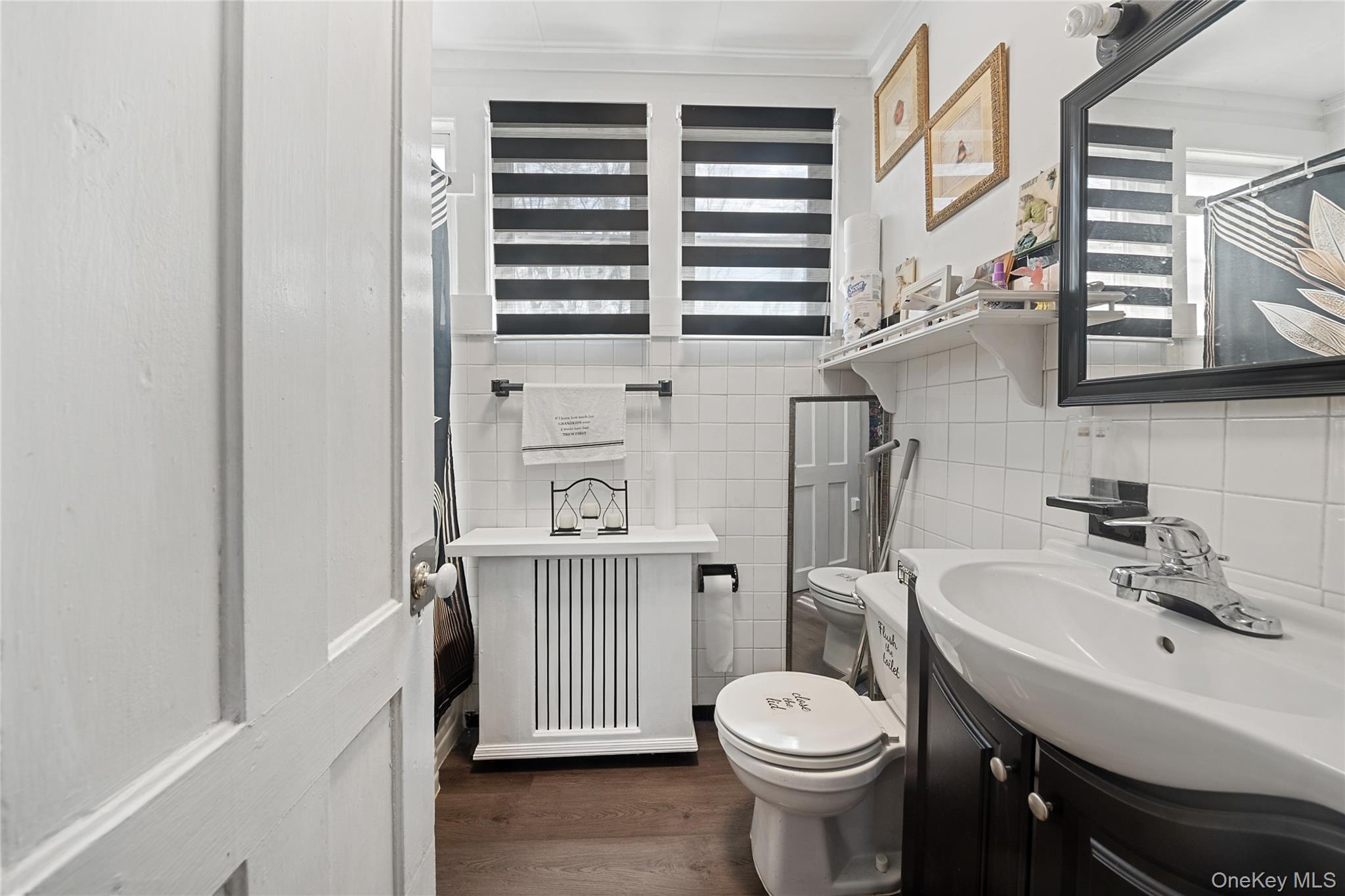 75 Chappaqua Road Briarcliff Manor, NY 10510 - Photo 28 of 50 Bathroom featuring a dark wood-finish floor, white subway tile walls, and a dark wood vanity with a white basin sink