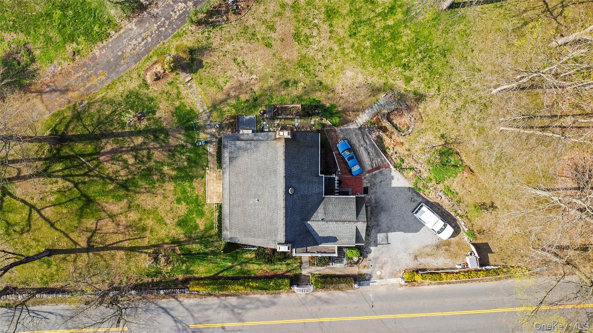75 Chappaqua Road Briarcliff Manor, NY 10510 - Photo 38 of 50 Property with a shingle roof, a paved driveway, and a front yard featuring mature trees