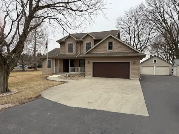 a front view of a house with yard and trees