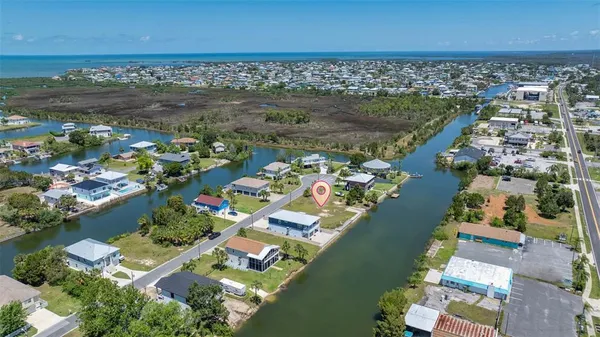 an aerial view of ocean and residential houses with outdoor space