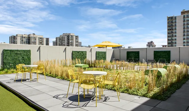 a view of a patio with couches table and chairs with wooden floor and fence