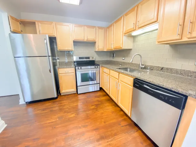 a kitchen with granite countertop stainless steel appliances a refrigerator a sink a stove a microwave and cabinets