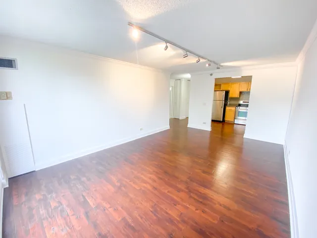 a view of empty room with wooden floor