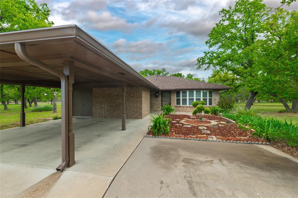 970 Live Oak Road Santo, TX 76472 - Photo 4 of 40 a front view of house with a garden