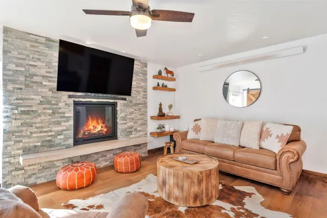 a living room with furniture a flat screen tv and a fireplace