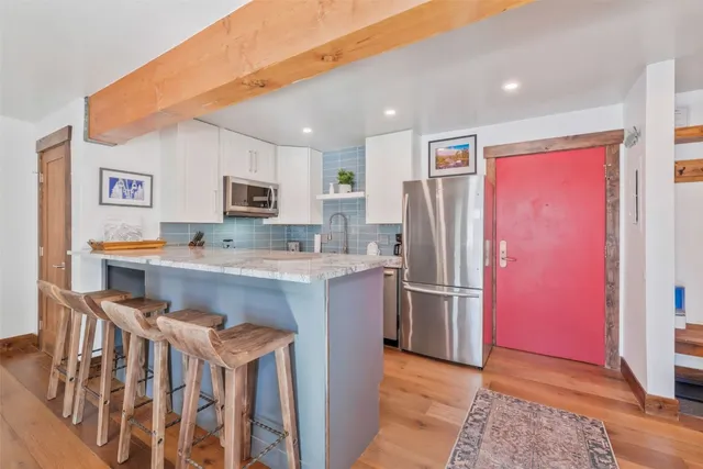 a kitchen with stainless steel appliances granite countertop a refrigerator and a stove top oven