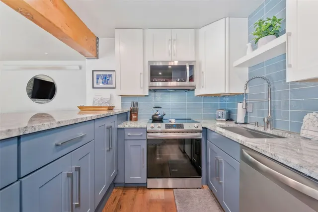a kitchen with stainless steel appliances granite countertop a sink and a stove