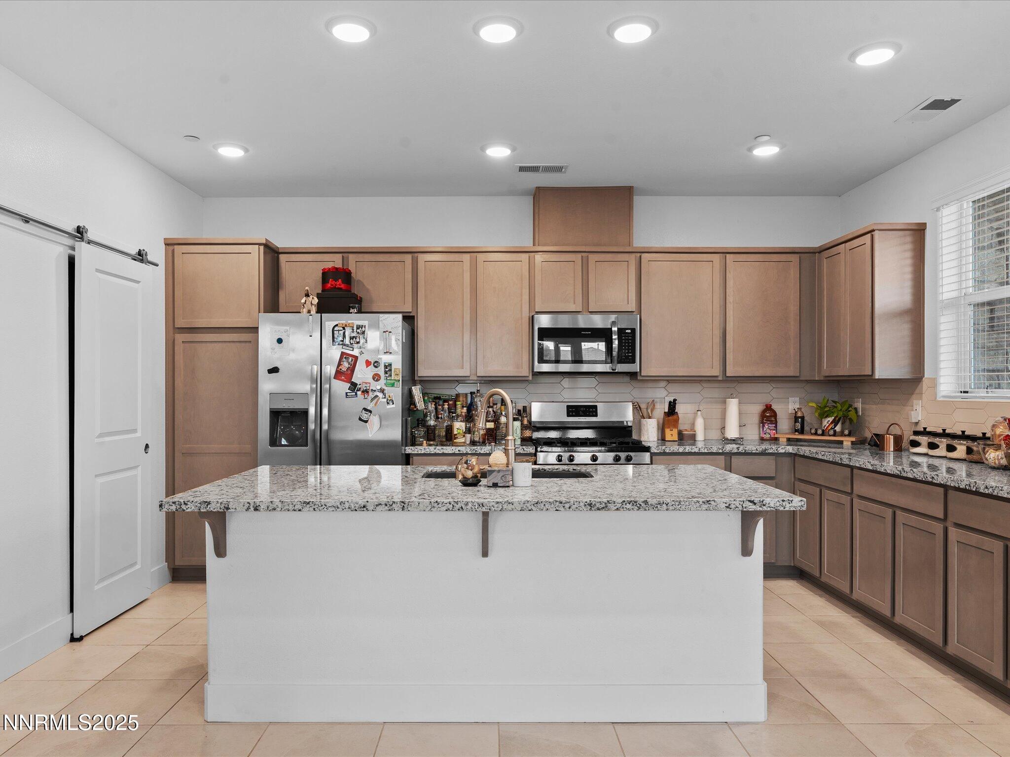 3621 Pulsar Lane, Unit 2 Carson City, NV 89705 - Photo 11 of 31 a kitchen with kitchen island stainless steel appliances a sink a stove a refrigerator cabinets and a window