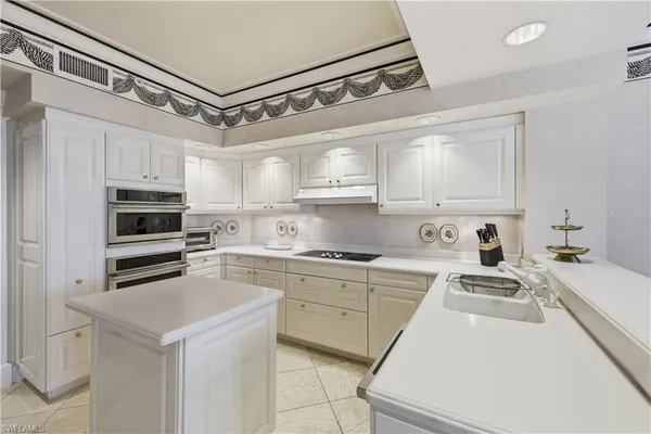 a kitchen with cabinets a sink and white appliances