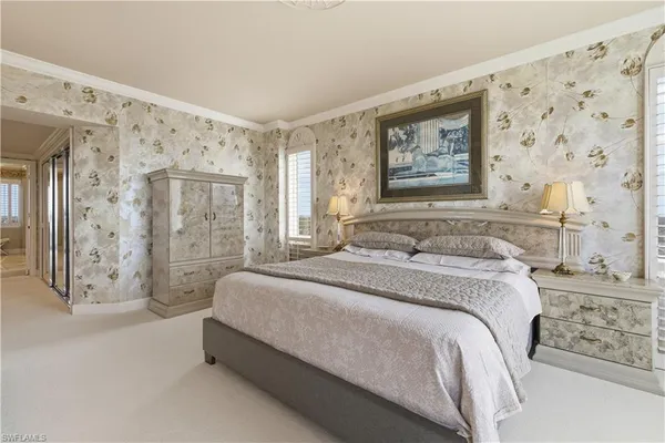 a spacious bedroom with a bed and a painting on the wall