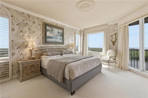 a spacious bedroom with a bed lamp and window