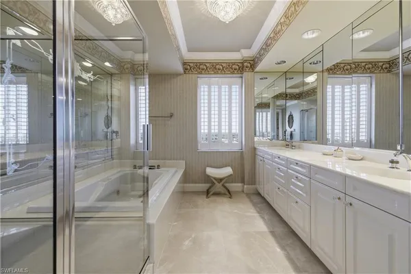 a spacious bathroom with a double vanity sink toilet mirror and bathtub