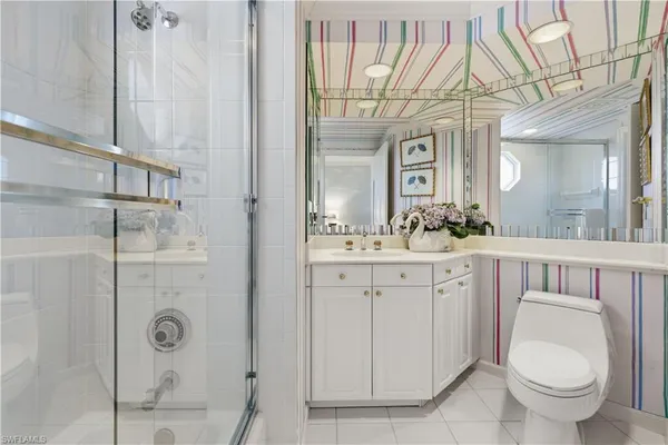 a spacious bathroom with a toilet a sink and mirror