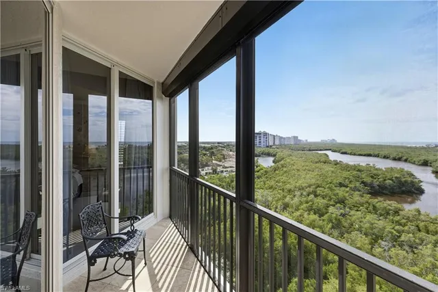 a living room with furniture and floor to ceiling windows