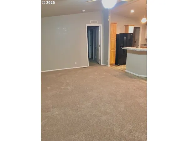 a view of a kitchen with refrigerator and a sink