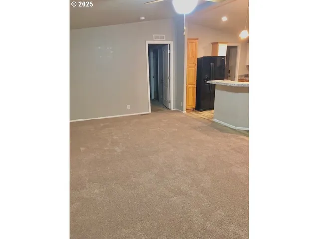 a view of a kitchen with refrigerator and a sink