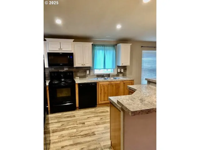 a kitchen with stainless steel appliances kitchen island granite countertop a sink and cabinets