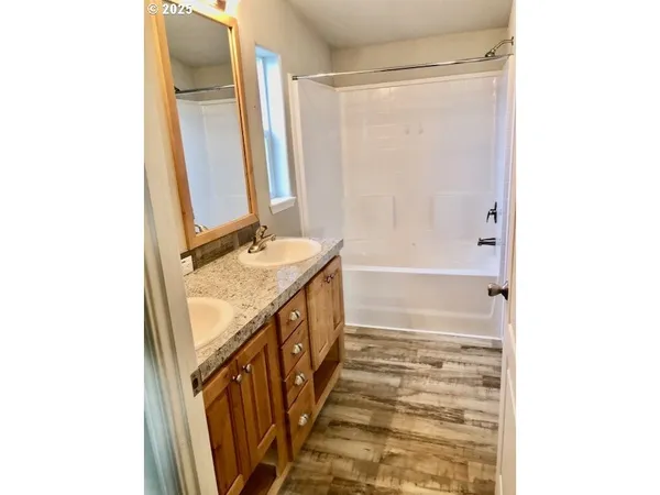 a bathroom with a double vanity sink a mirror and a bathtub