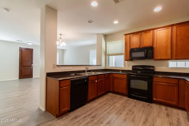 a kitchen with stainless steel appliances granite countertop a stove a sink and a microwave