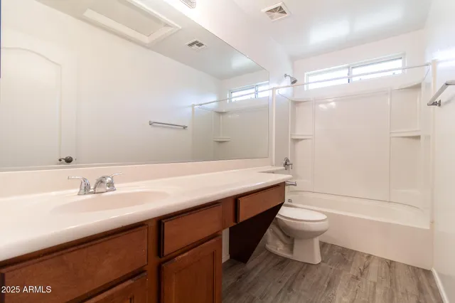 a bathroom with a sink a toilet a mirror and shower