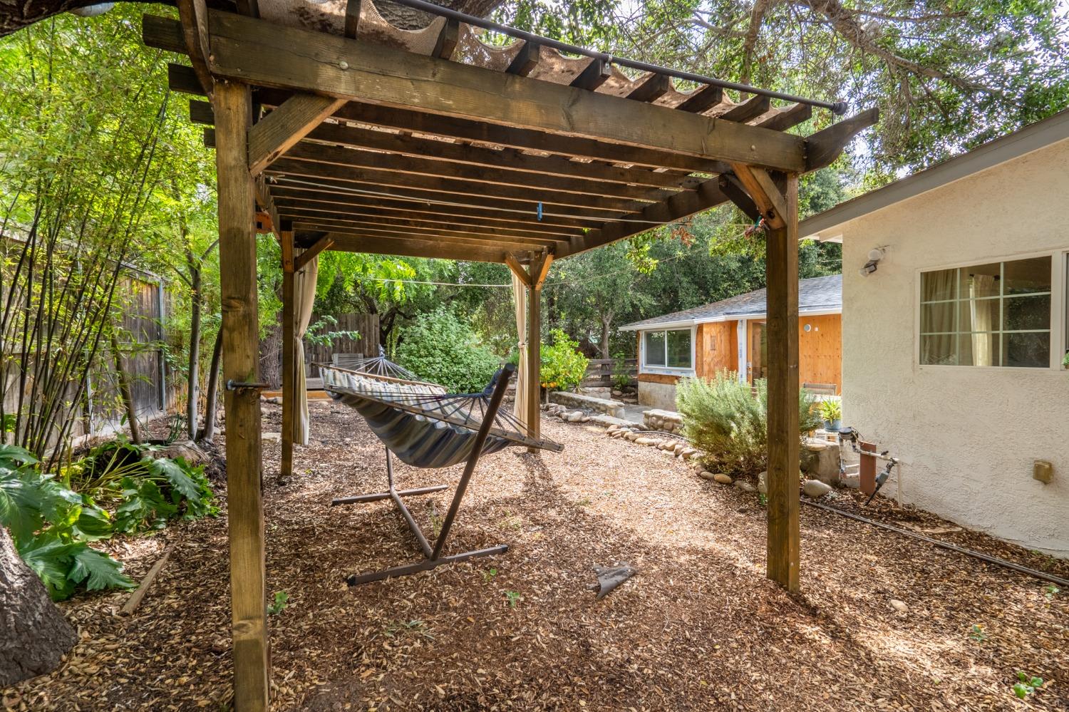 412 Franklin Drive Ojai, CA 93023 - Photo 40 of 50 a backyard of a house with table and chairs under an umbrella